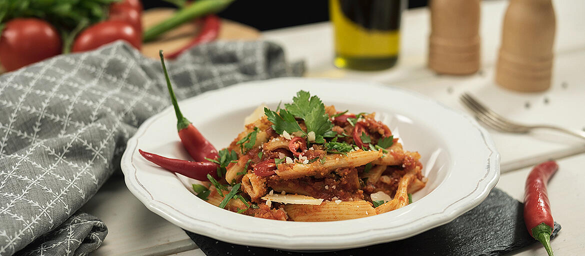 Penne all arrabbiata in a white plate.