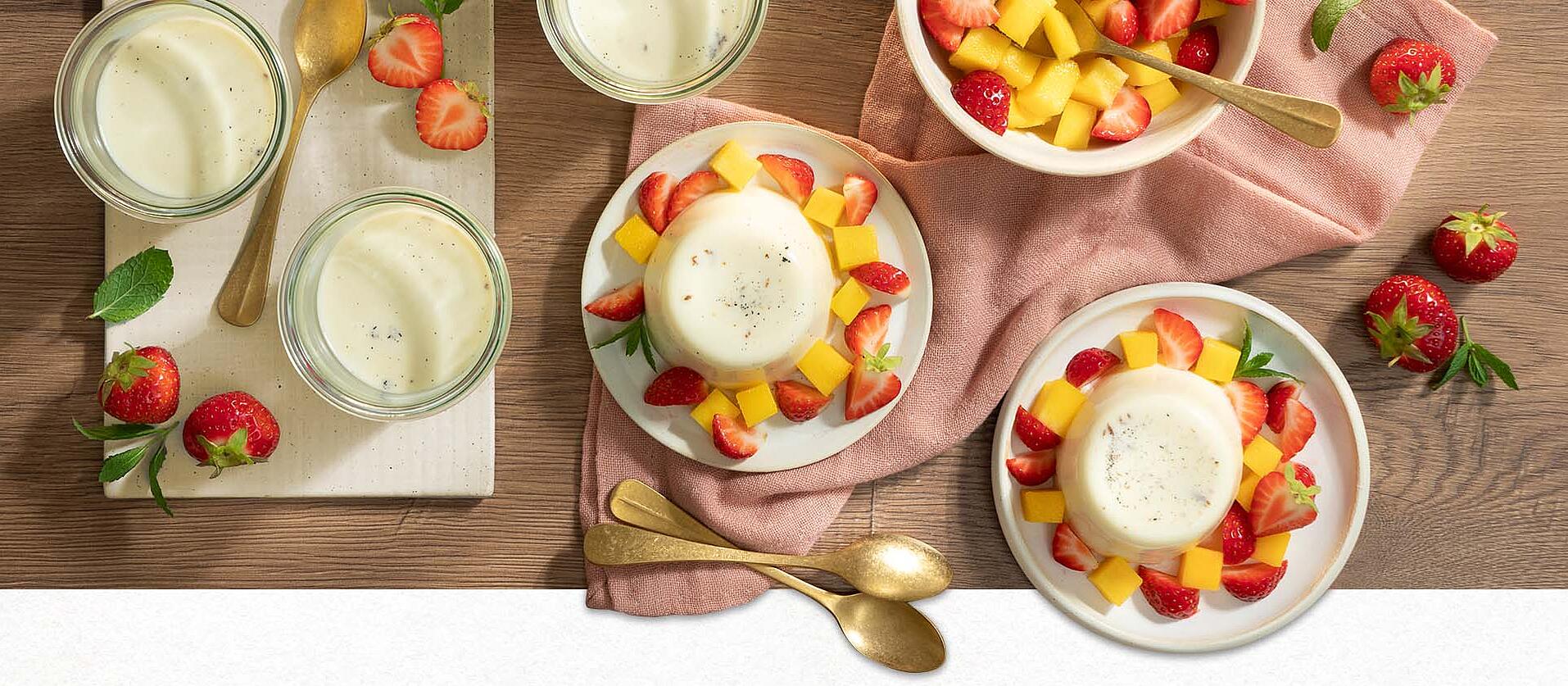 Dessert im Glas: Auf einem Teller steht ein Glas gefüllt mit Limoncello Panna Cotta und Mango-Topping