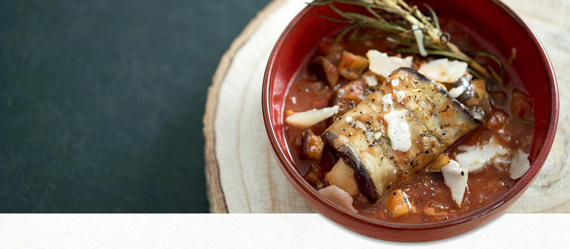 Ein geschmortes Auberginenröllchen in Tomatensauce in einer Schüssel