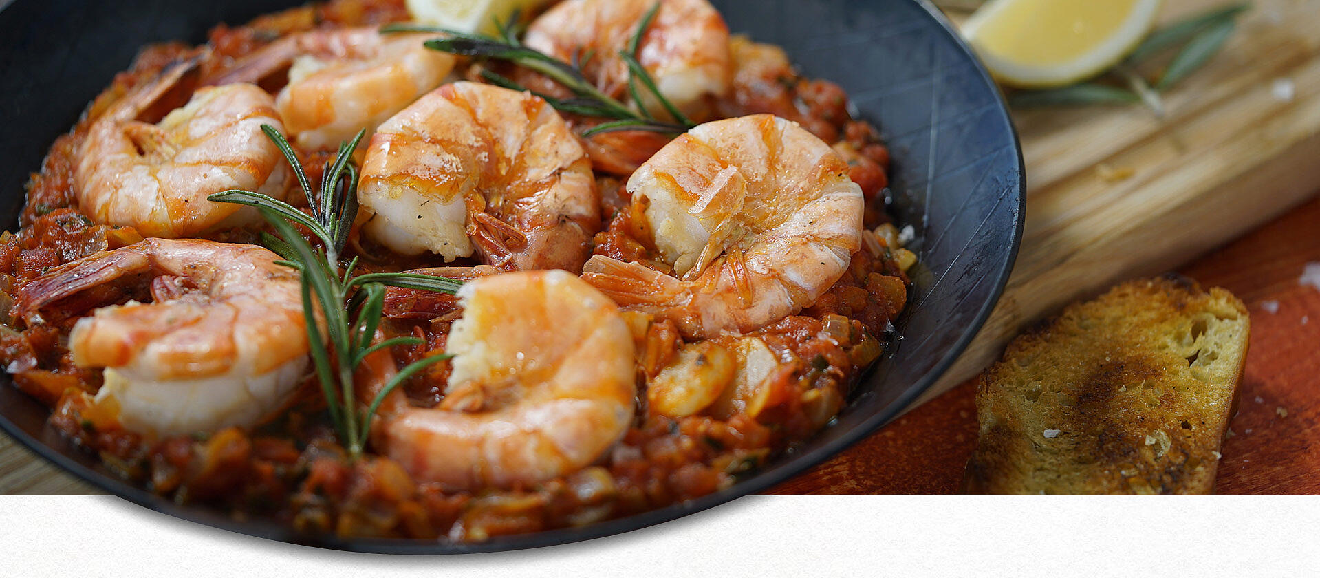 Gamberi rustici on a black plate.