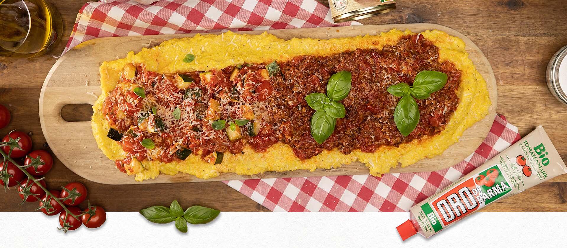 Eine Polenta sul tavolo mit zwei Toppings auf einem Holzbrett