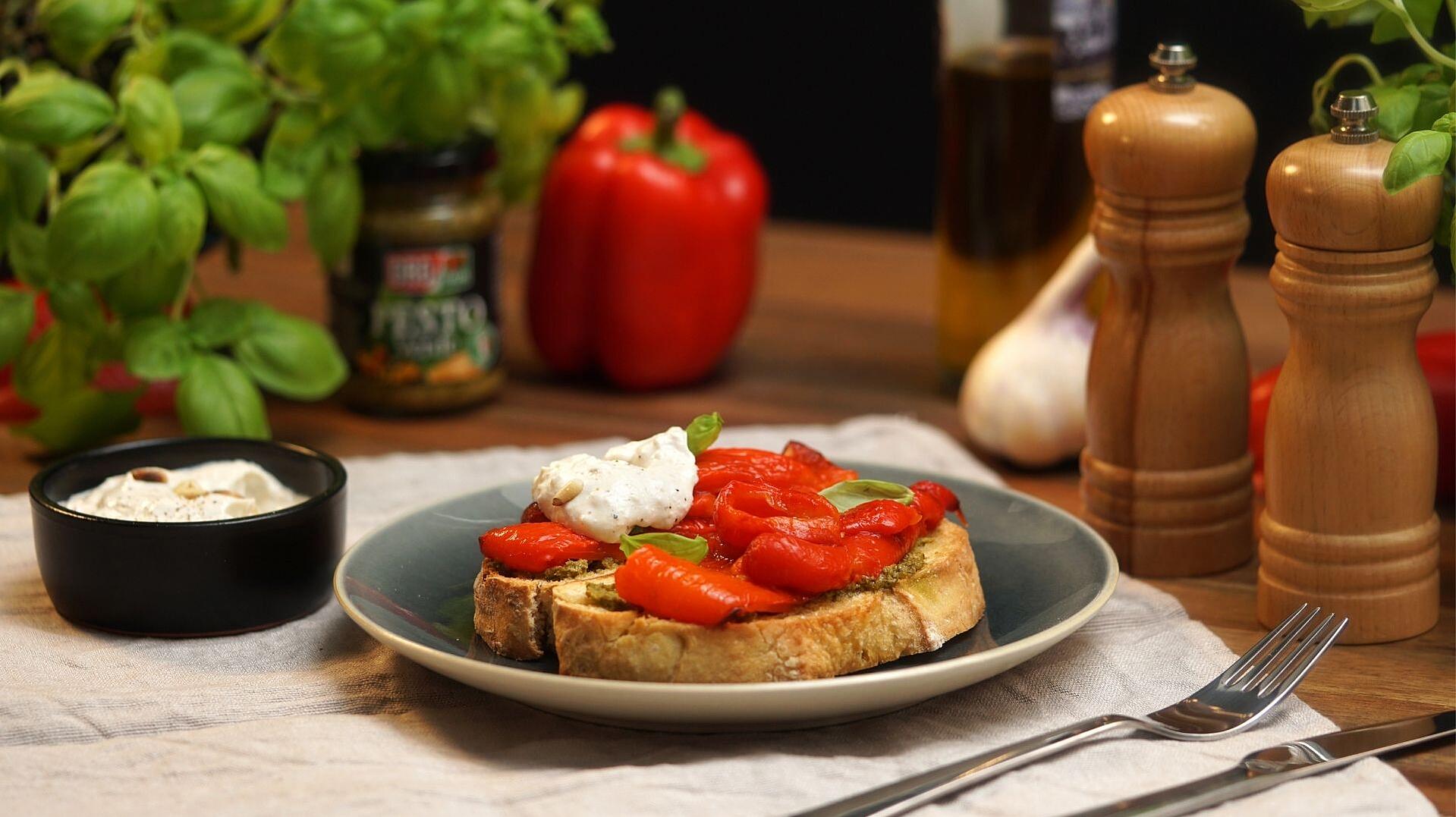 Zwei Scheiben Ciabatta-Brot mit gegrillter Paprika und Ricotta-Pinienkercreme belegt