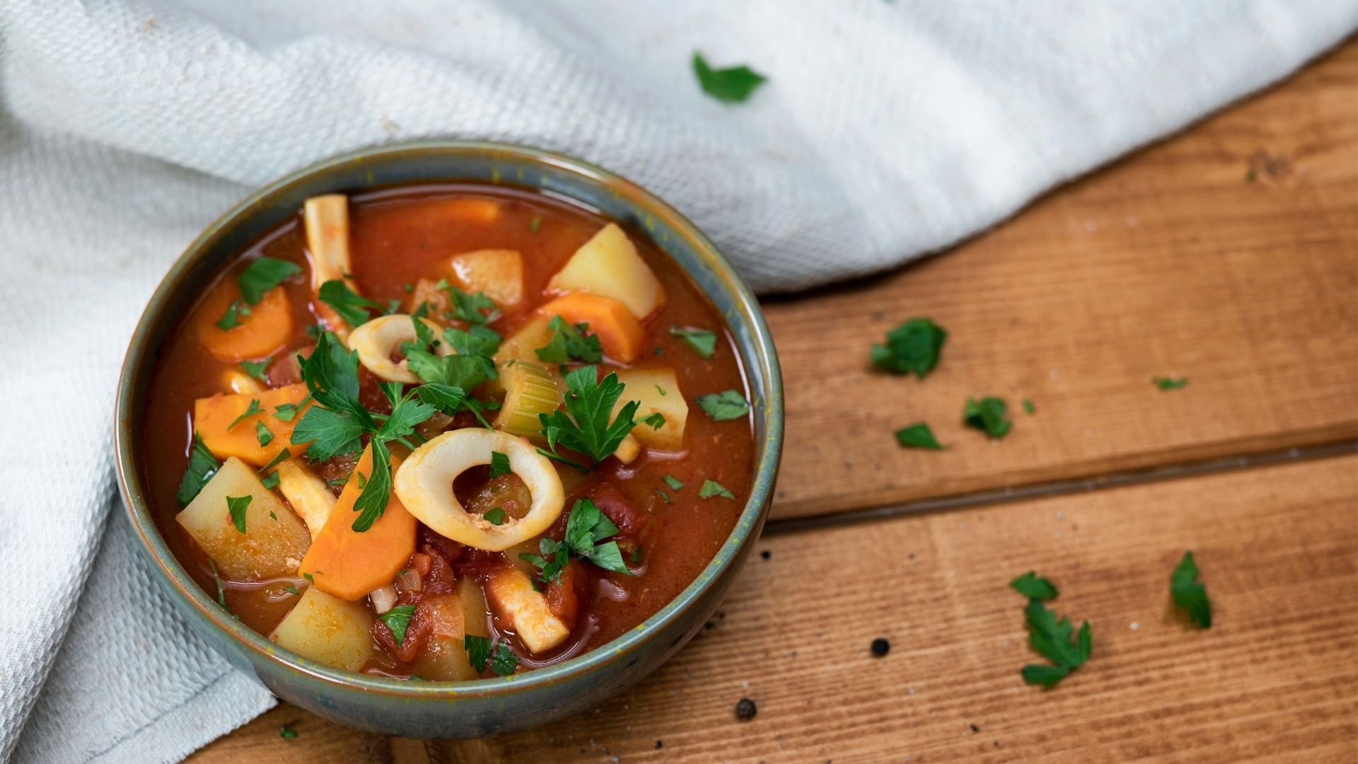 Eine Schüssel gefüllt mit Tintenfischsuppe, garniert mit Petersilie