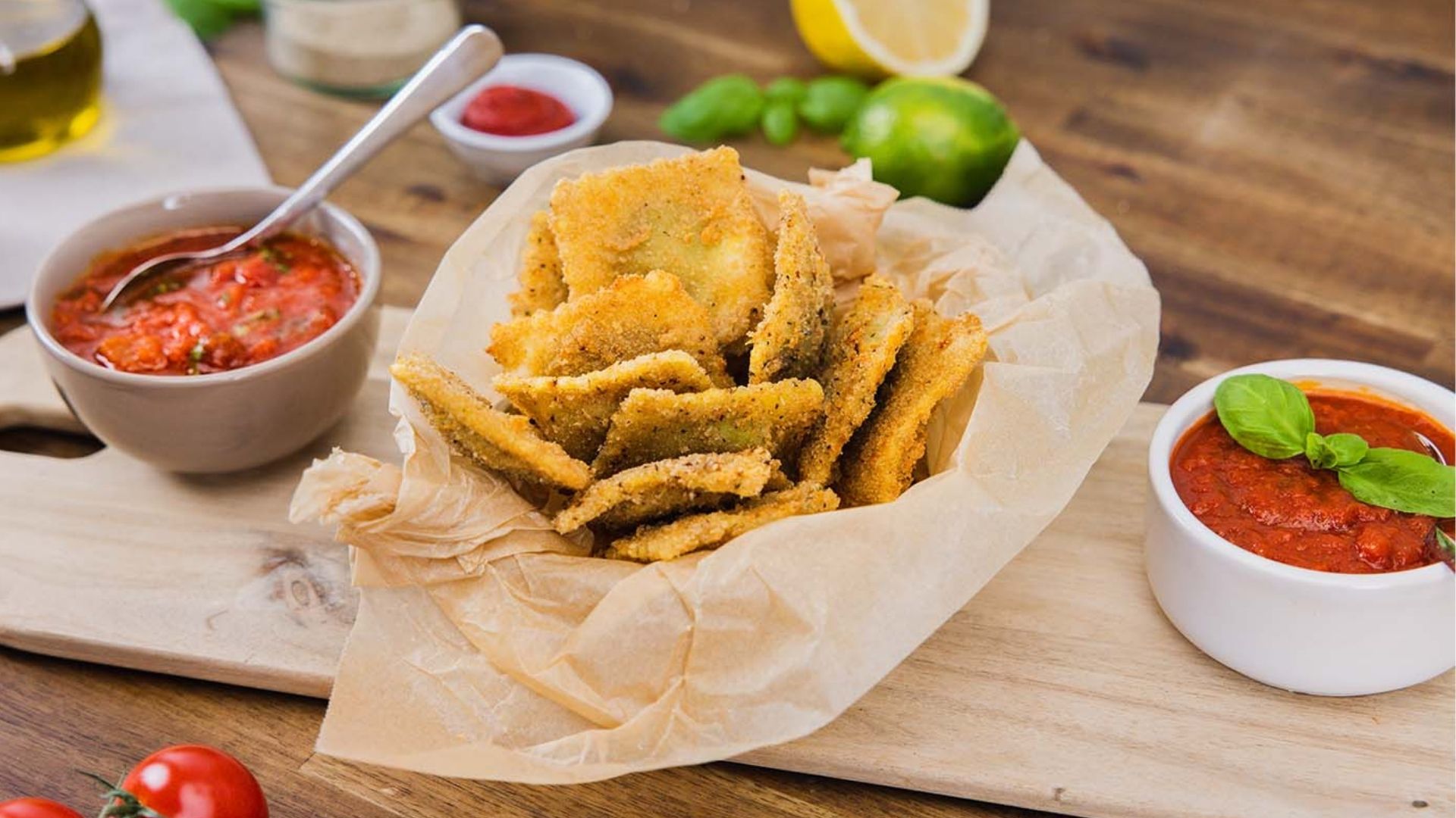 Frittierte Ravioli auf einem Brettchen mit Tomaten-Dips