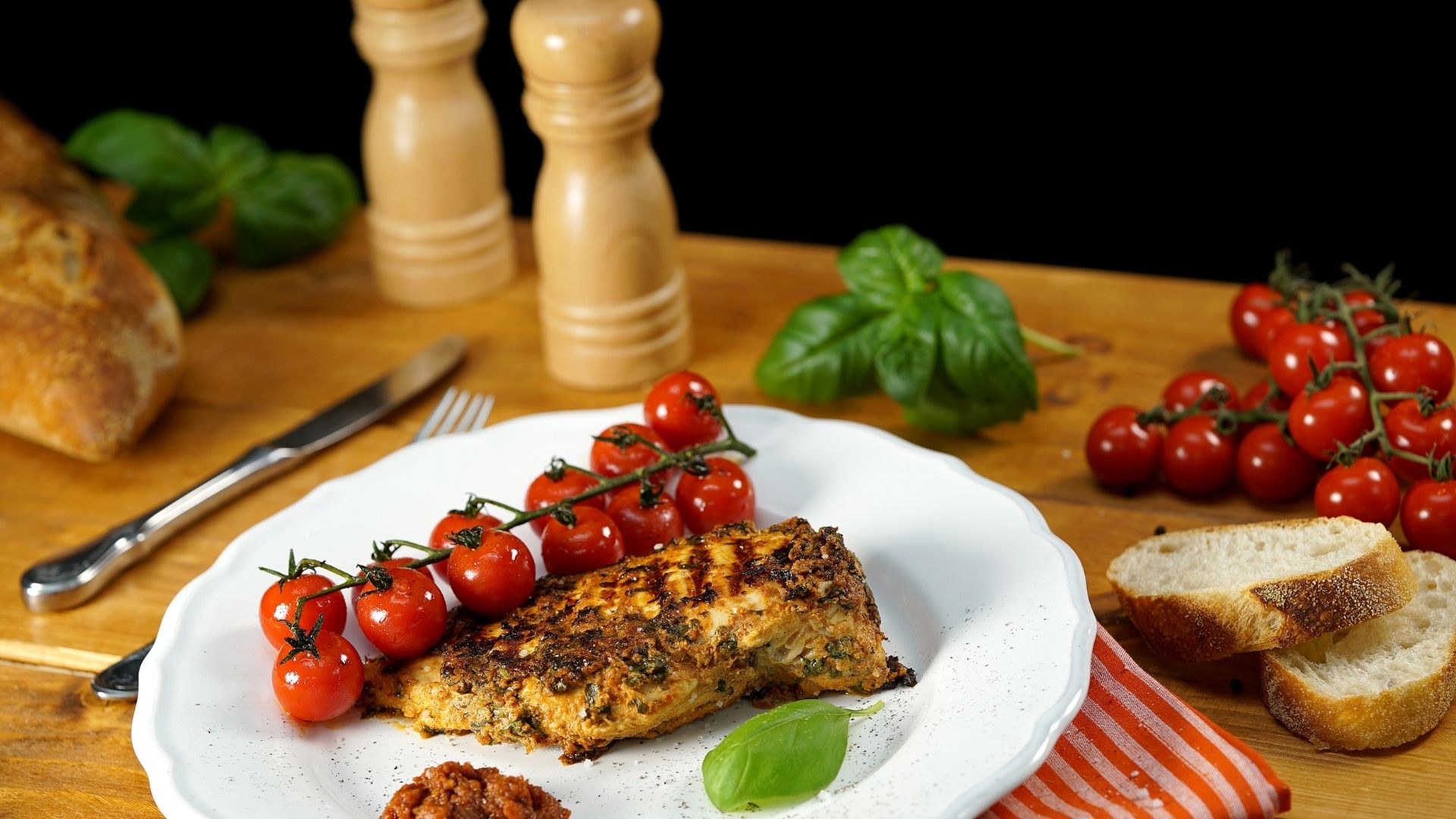 Auf einem Teller liegt ein Hähnchenbrustfilet mit Pesto-Rosso-Joghurt-Marinade