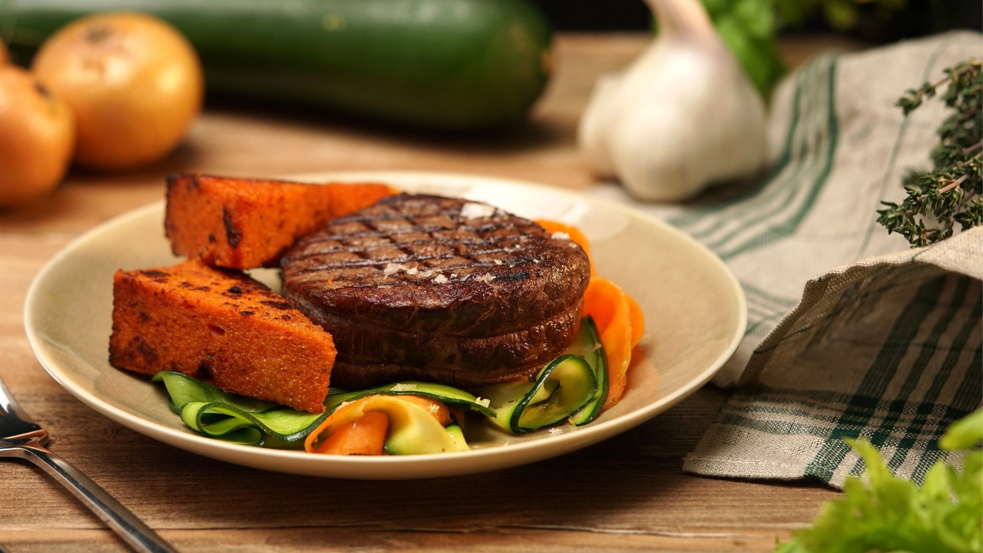 Ein Teller mit Rinderfilet auf Gemüse-Pappardelle und Tomatenpolenta