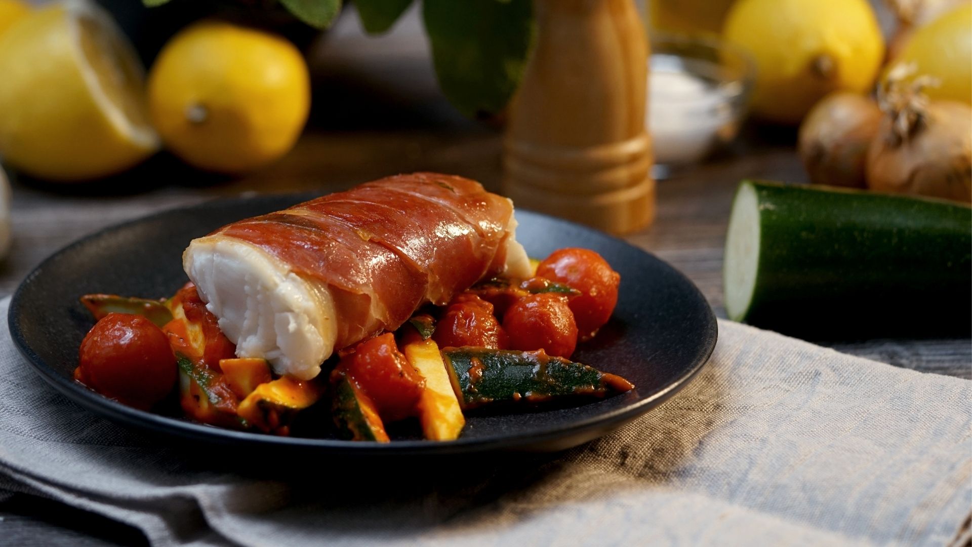 Kabeljau Saltimbocca auf einem Teller mit Beilagen 