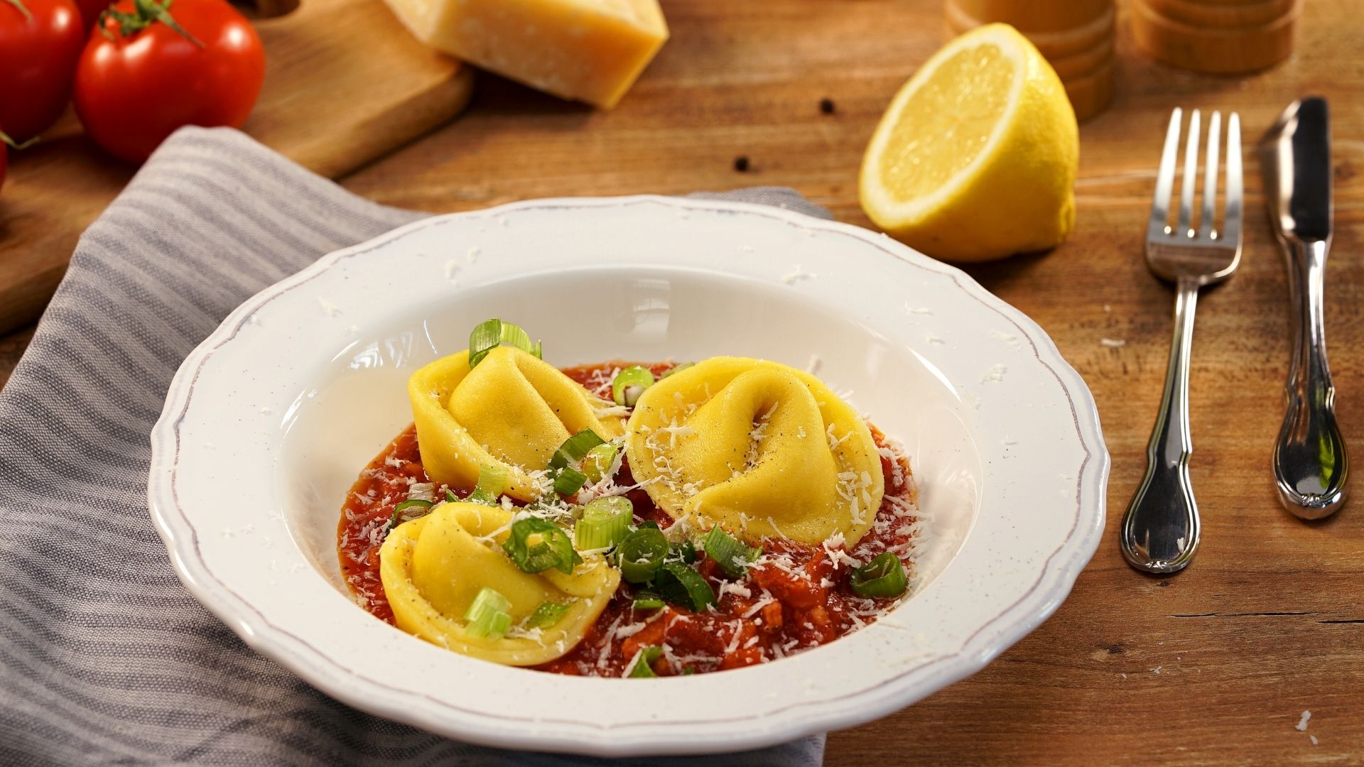 Ein Pastateller gefüllt mit Tortellini auf Tomaten-Bacon-Sauce